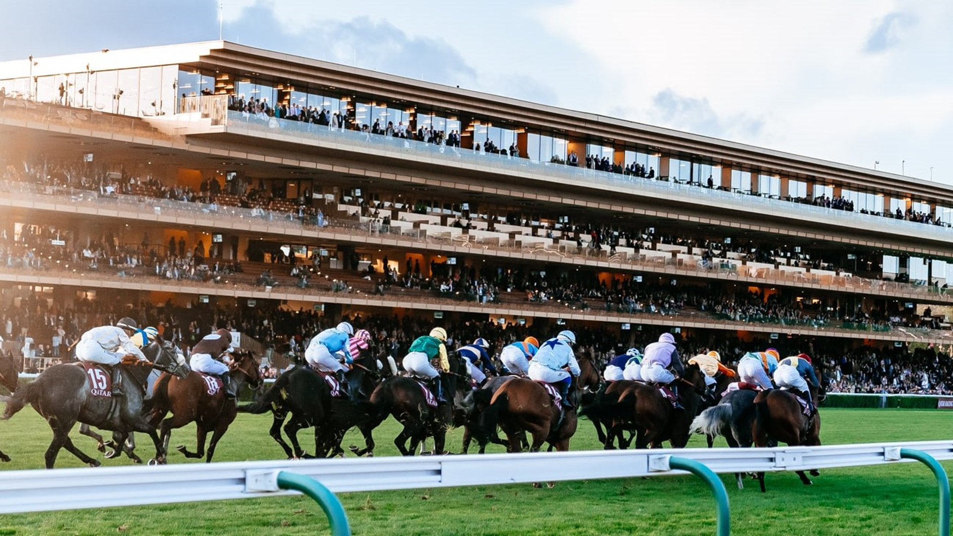 Racehorses in full flight past packed grandstands (Day At The Races / DATRS)
