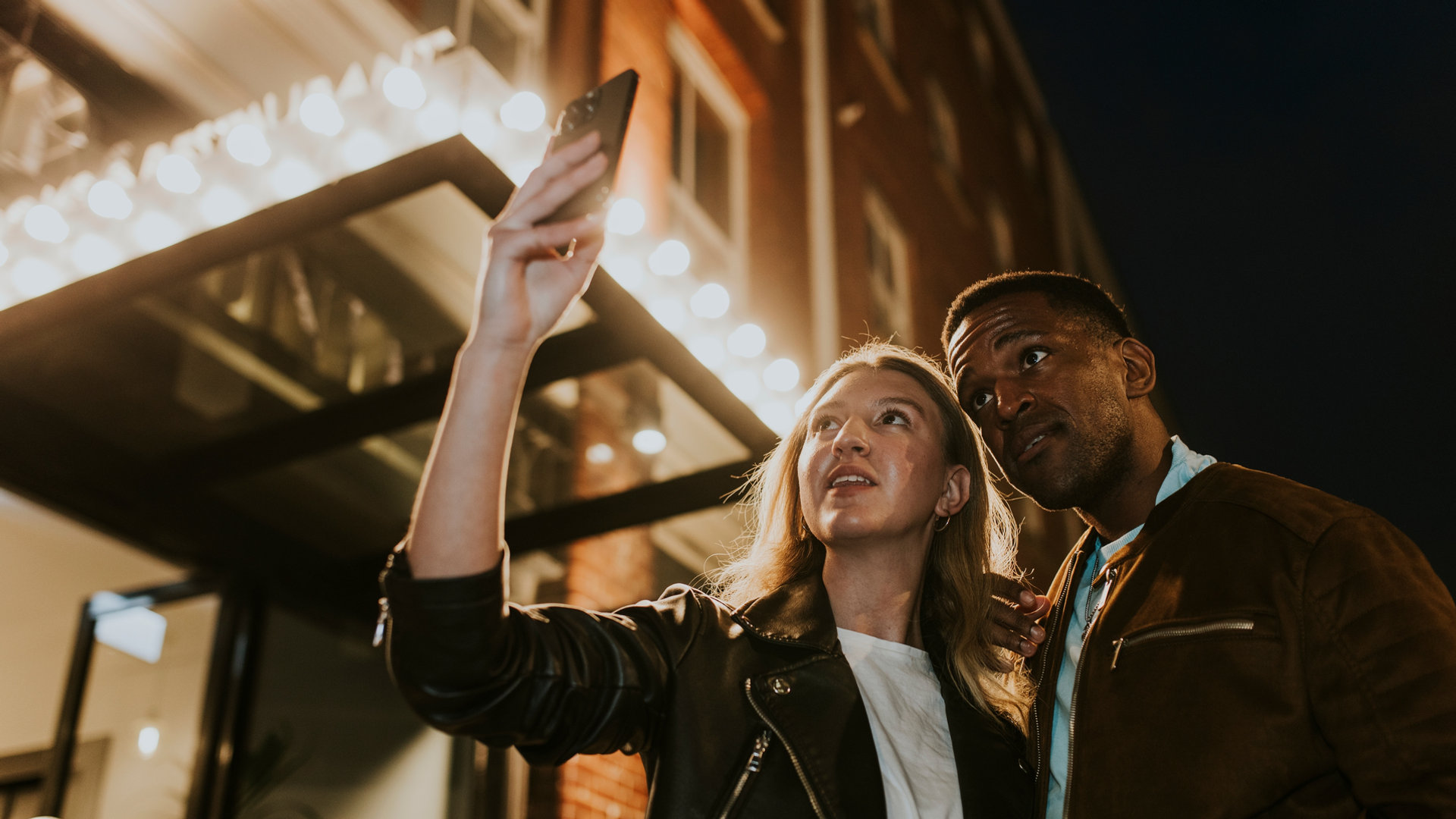 Couple checking mobile tickets outside a venue at night (Ticketpipe)