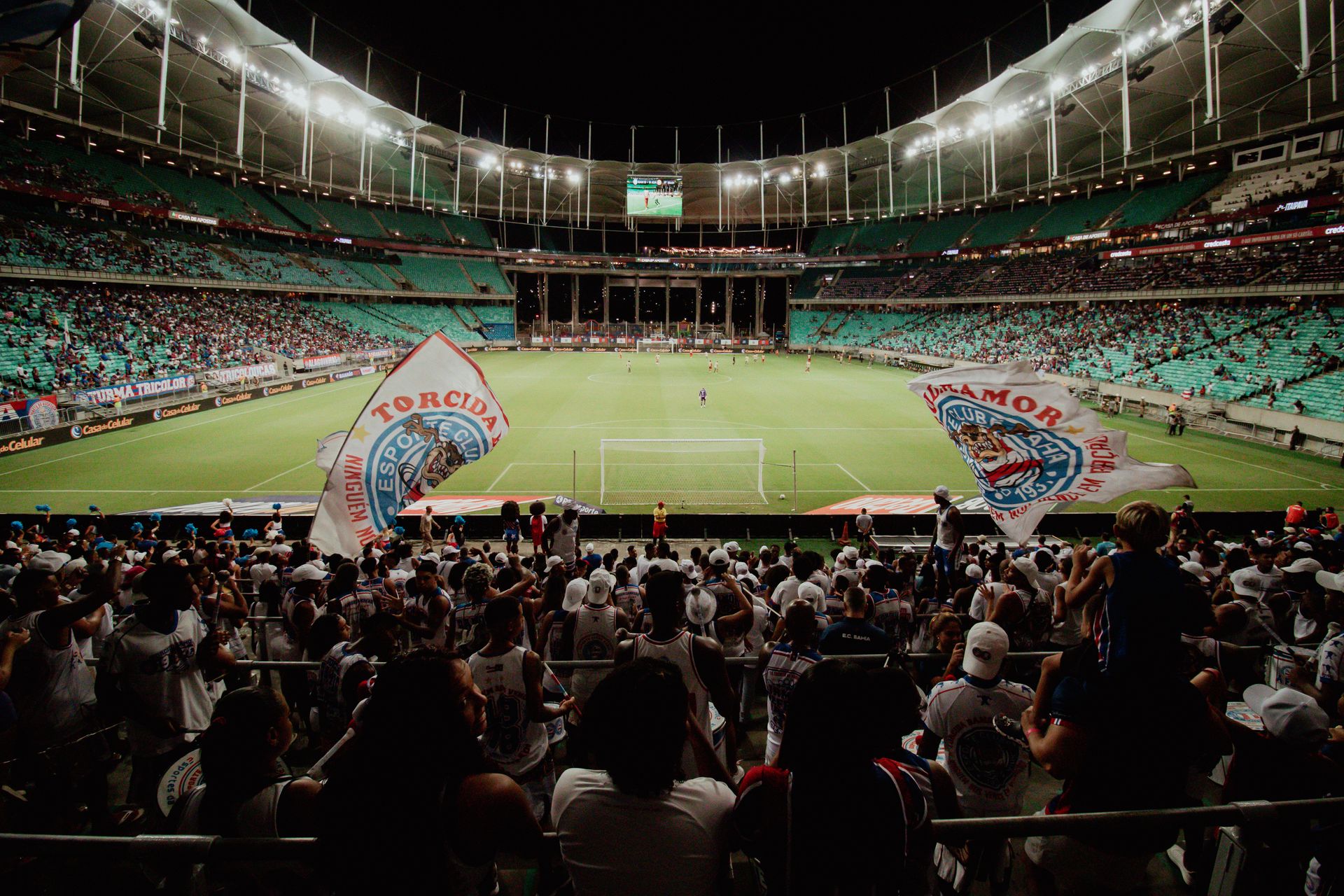 Fans at a packed stadium during a night match (Your Sports Travel)